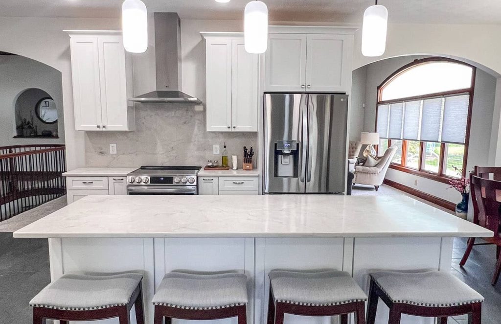 Kitchen remodeling with a large island, stainless steel appliances, and white cabinetry by BGW Construction in Avon.