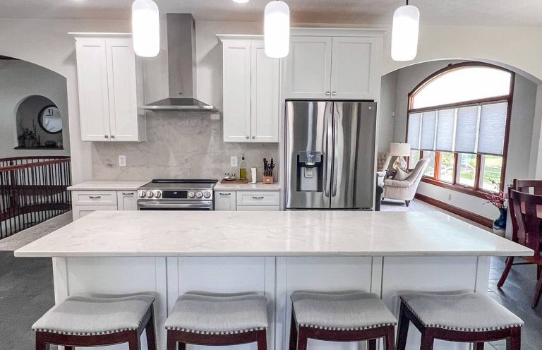 Kitchen remodeling with a large island, stainless steel appliances, and white cabinetry by BGW Construction in Avon.