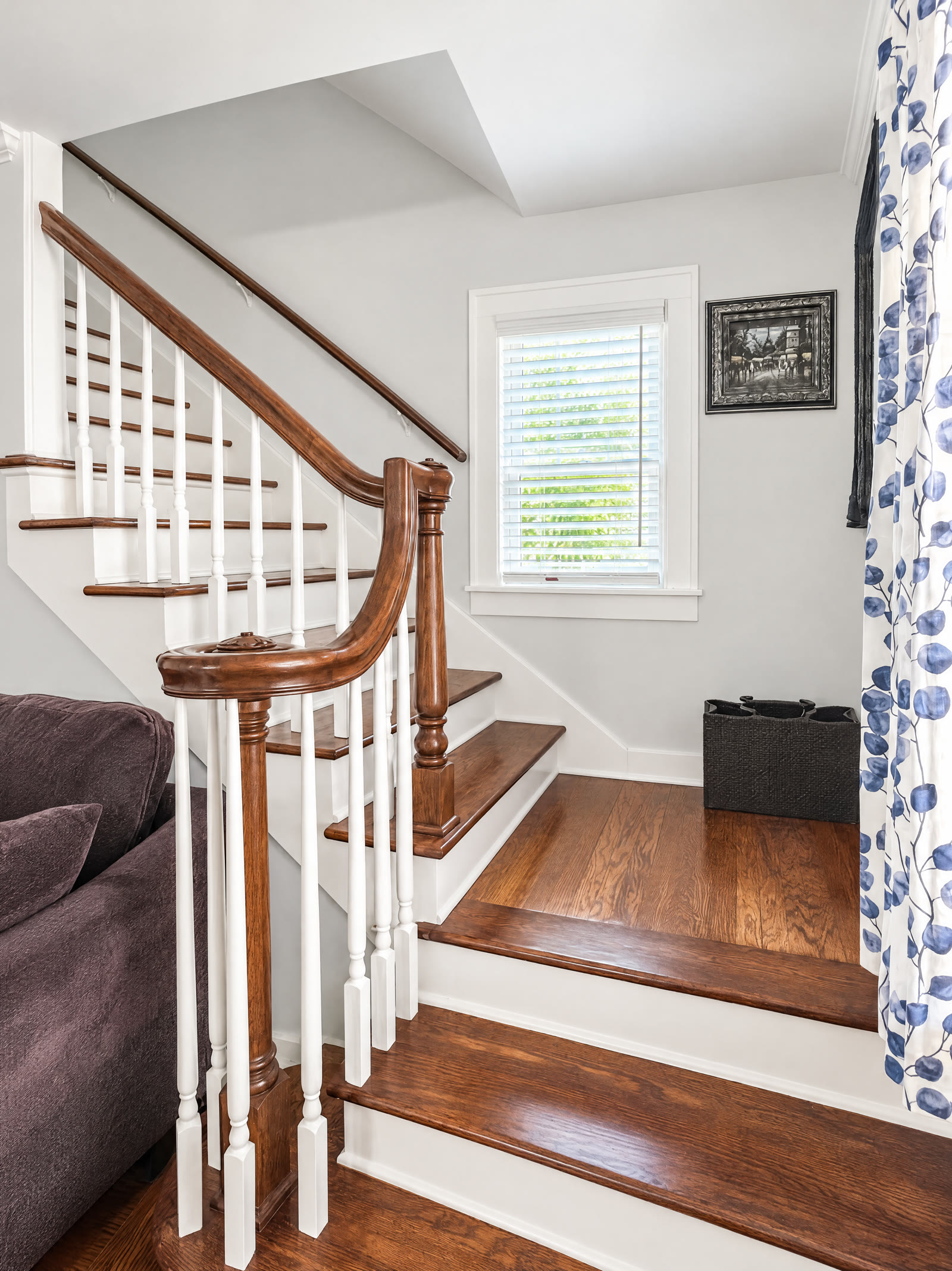 Original wood staircase with refinished treads, dark handrail and white spindles