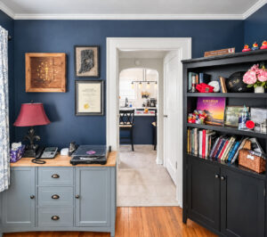 Preserved arched doorway connecting a navy home office to the renovated kitchen in a 1914 Stilesville bungalow