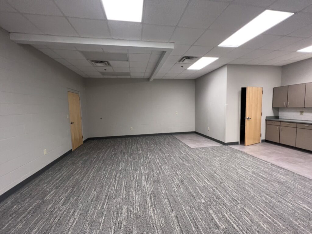 Before the DCS safe space renovation: an underused room at Kingsway Christian Church in Avon, Indiana, with commercial carpet squares and fluorescent ceiling lights
