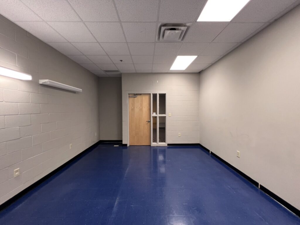Before the renovation: a block-walled room with commercial tile flooring and fluorescent lighting that BGW Construction converted into part of the DCS safe space in Avon, Indiana