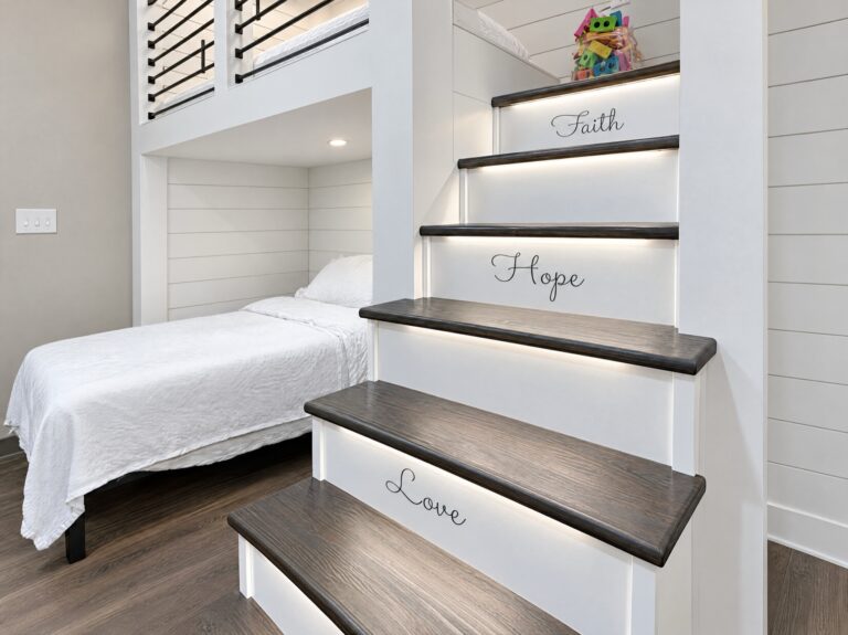 Custom built-in bunk beds by BGW Construction in the DCS safe space at Kingsway Christian Church in Avon, Indiana, with a lit staircase lettered Faith, Hope, Love and 1 Corinthians 13:13
