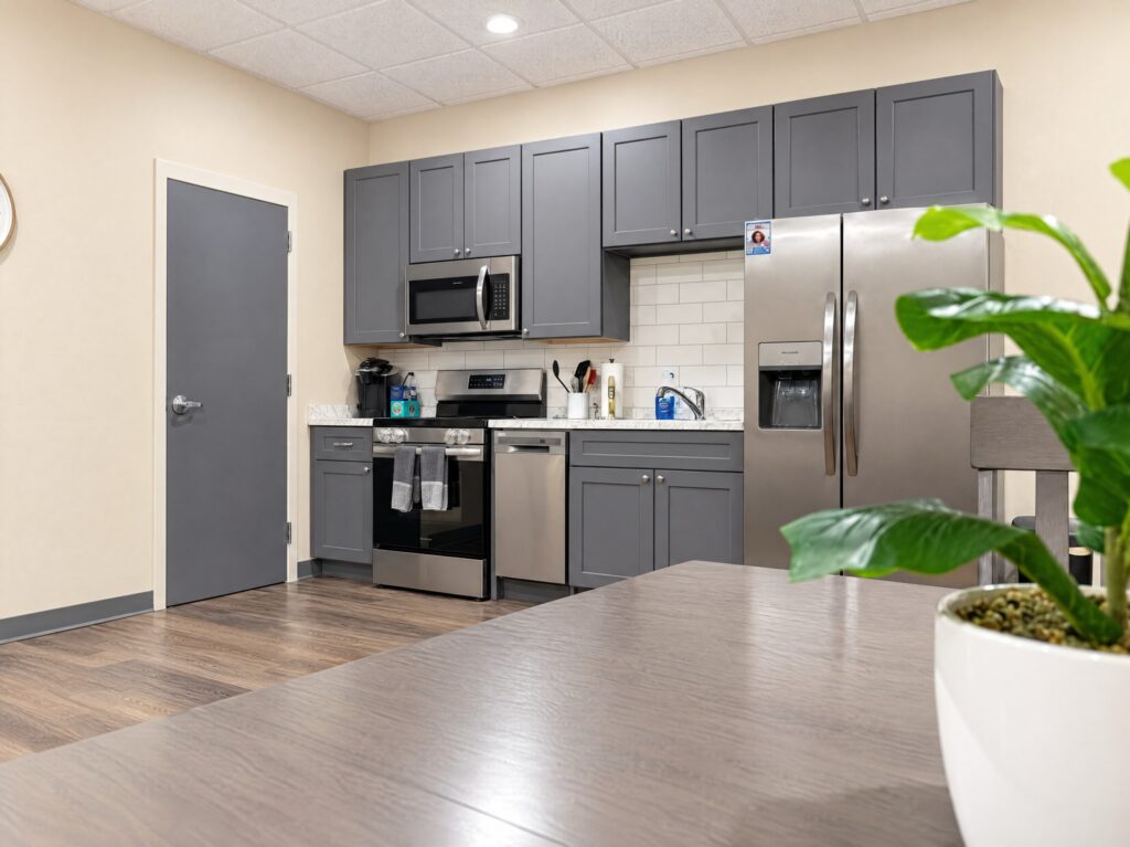 Kitchen in the DCS safe space in Avon, Indiana, remodeled by BGW Construction with gray Shaker-style cabinets, a white subway tile backsplash, stainless appliances, LVP flooring and recessed lighting