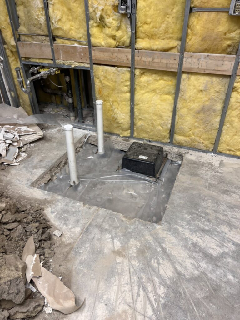 New PVC drain lines and a tub drain box set below the slab for the DCS safe space full bathroom, built by BGW Construction in Avon, Indiana