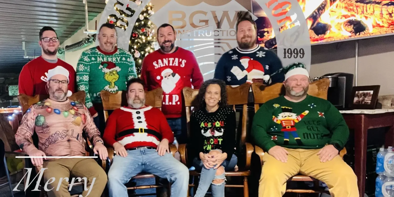 The BGW Construction team posing in festive Christmas sweaters in front of a decorated tree and fireplace, celebrating the holiday season in Plainfield, Indiana.