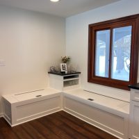 Built-in corner bench seating with lift-top lids and small glassware bar station