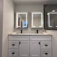 Modern double sink vanity with white cabinetry and two LED mirrors